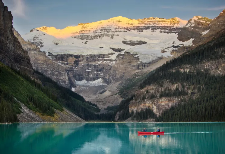 A couple canoeing on Lake Louise during sunset
