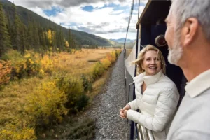 Couple enjoying the outdoor view upon the Viewing Platform on Rocky Mountaineer's Goldleaf Service.