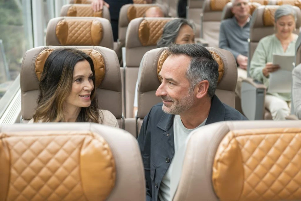 Couple chatting in their seats, aboard the Rocky Mountaineer GoldLeaf train.