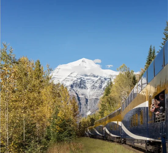 Exterior of Rocky Mountaineer Train travelling by Mount Robson from the GoldLeaf Service vestibule on Journey through the Clouds.